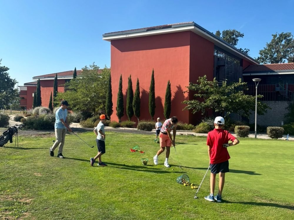 Groupe de l&rsquo;école de golf enfant sur le practice du Golf du Claux Amic, devant le club-house